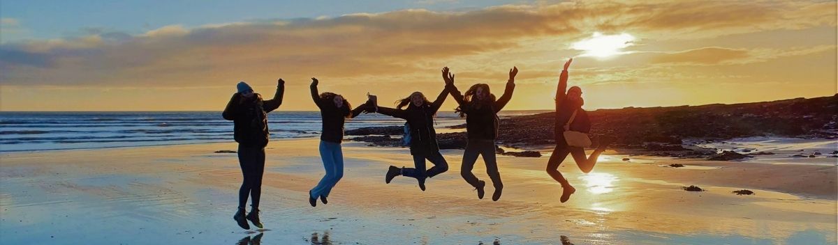 students jumping on beach