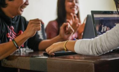 Glada studenter framför sina datorer