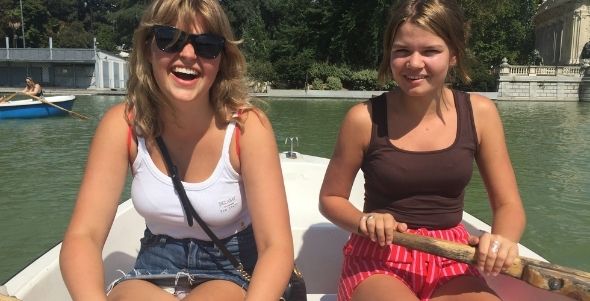 Två studenter ror en båt på sjön