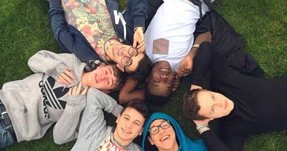 High school studenter ligger i en cirkel på gräset