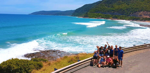 Utbytesstudenter på resa i Australien. Vackert turkosblå vatten i bakgrunden