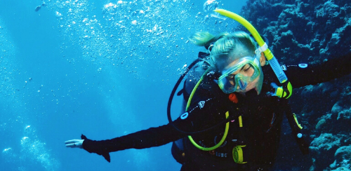 En tjej dyker i full utrustning i havet i Australien