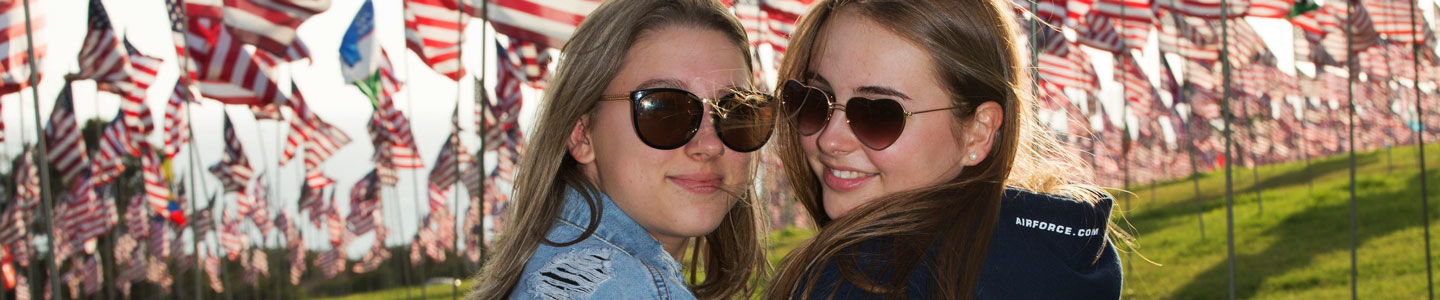 Utbytesstudent med vän och amerikanska flaggor i bakgrunden