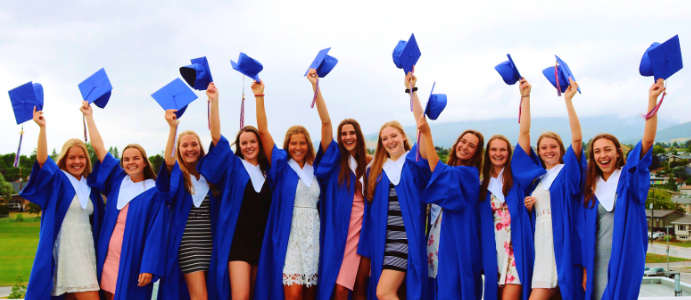 Glada tjejer som tar examen från high school i USA